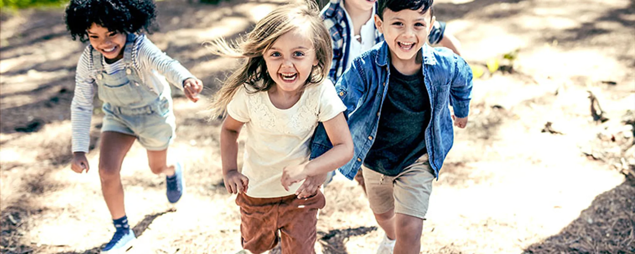Eine Gruppe von Kindern rennt fröhlich im Freien, vertieft in spielerische Beschäftigungen. Die Szene ist lebendig und erinnert an einen Bildschirm voller lebhafter Farben und Bewegung.