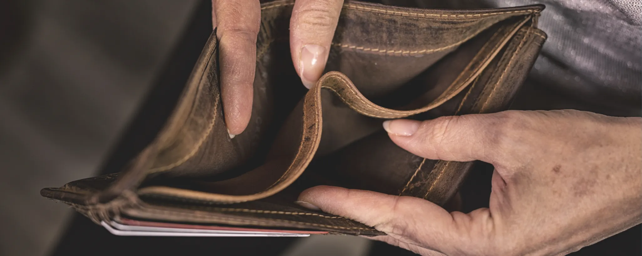 Eine leere Brieftasche in den Händen einer älteren Frau. Wie lässt sich Altersarmut vorbeugen?